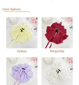 Detail view of large satin bow hair claws in yellow, wine red, purple, and white colors
