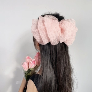 Pink seersucker oversized bow hair clip shown on a model for a sweet aesthetic look