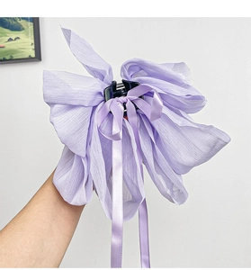 Close-up of a purple chiffon bow hair claw with long ribbon streamers for elegant styling
