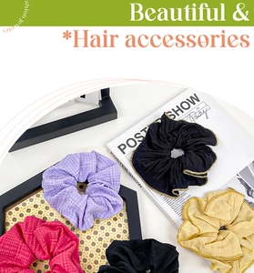Close-up of stylish fabric scrunchies with gold trim and plaid patterns on a tray