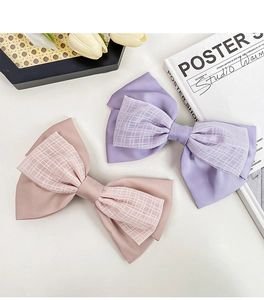 Détail de barrettes à cheveux à double nœud en satin rose et violet avec texture mesh