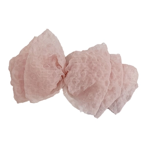 Pink seersucker bow hair clip with textured fabric and elegant layered spring design