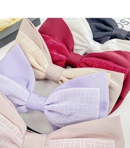 Détail de grandes barrettes à nœuds en satin de diverses couleurs avec couches de tulle