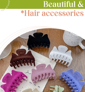Détail de pinces à cheveux en velours de couleurs variées sur un bureau en bois