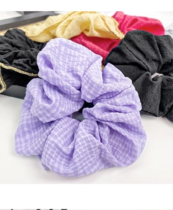 Detail of multi-colored scrunchies with gold trim and purple plaid fabric texture