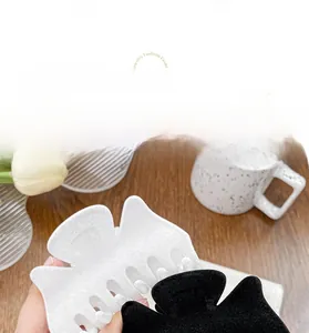 Vue détaillée de grandes pinces à cheveux papillon floquées en noir et blanc élégant