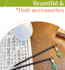 Detail of vintage wooden hair sticks with green leaf charms and white beads on a desk