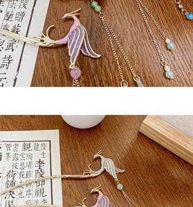 Detail of golden phoenix hair stick with colorful enamel wings and long beaded tassels