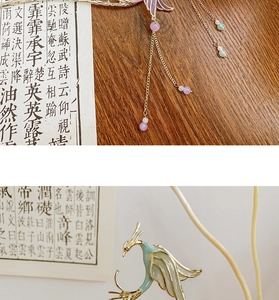 Close-up of golden bird hair stick with blue enamel detail and hanging purple beads