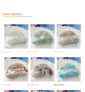 Detailed color selection of acetate hair claws in marble textures on white ceramic plates