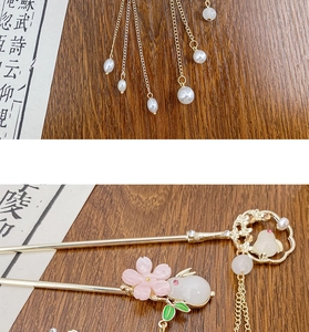Nahaufnahme des goldenen Haarstabs mit Hasen-Charm, Blumen-Resin und langen Perlenquasten