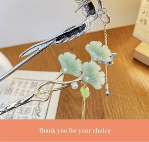 Detail of silver phoenix hair stick with green ginkgo leaves and a pearl tassel