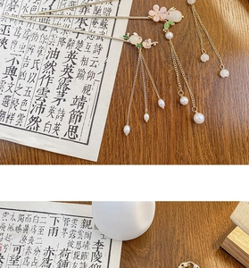 Detail einer goldenen chinesischen Haarnadel mit weißem Hasen und Perlenquasten