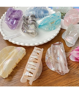 Detail of colorful marble acetate hair claws with premium pearlescent finish in a white plate