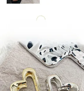 Detailed close-up of hollow metal heart hair claws in polished gold and silver finishes
