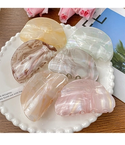 Detailed set of six marble texture half-round acetate hair claws in a decorative pearl tray