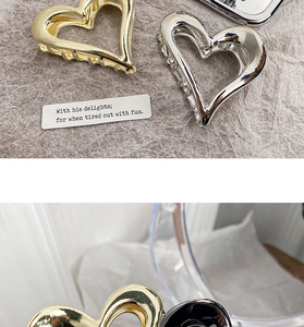 Close-up of heart-shaped metal hair claws in gold and silver with a polished finish