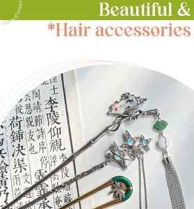 Macro detail of silver Chinese style fan hair pins with tassels and jade on vintage books