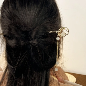 Chinesischer Haarstab in Gold mit Jade-Hase und langen Perlenquasten auf dunklem Haar