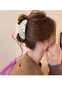 Détail d'une grande pince à cheveux nacrée avec strass colorés portée sur cheveux longs