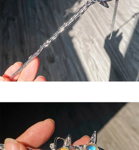 Macro shot of silver fan hairpin with blue opal bead, starry detail and metal tassel