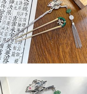 Detail of silver fan hair pin with long tassel and golden U-shaped hairpin accessory