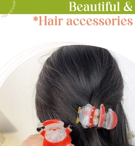 Détail d'une pince à cheveux Père Noël en acrylique avec strass portée sur les cheveux