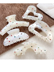 Détail de cinq pinces à cheveux en acétate blanc perle avec strass colorés étincelants