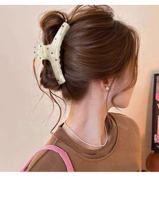 Grosse pince à cheveux blanc nacré avec strass colorés sur une coiffure chignon
