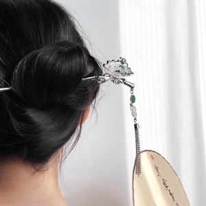 Silver Chinese fan hair stick with mountain pattern and green beads on model