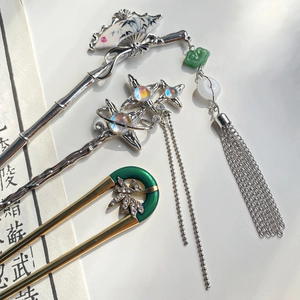 Elegant Chinese fan hairpins with tassels and bamboo motifs on a minimalist white backdrop