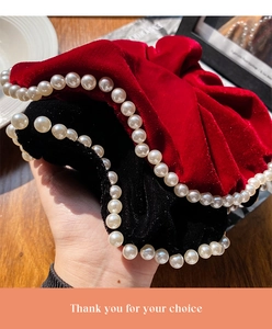 Detail of red and black velvet scrunchies with white faux pearl trim decoration