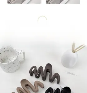 Detail view of large matte wavy hair claw clips in various earth tone colors