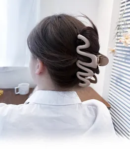 Detail view of large apricot wavy hair claw clip styled on long hair for high volume hold
