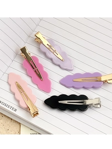 Five wave-edge acrylic hair clips in assorted colors displayed on a notebook