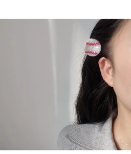 Détail d'une pince à cheveux en acétate forme baseball portée pour un style sportif