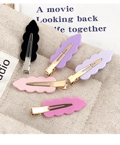 Detail view of five-piece acrylic hair clip set with wavy edges and gold metal clips