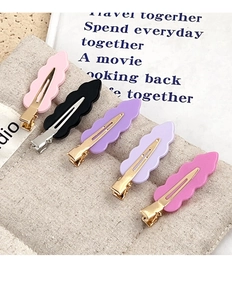 Detailed set of five colorful acrylic wave hair clips on a soft linen background