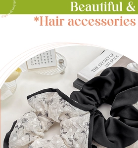 Detail view of elegant black satin and white rose floral scrunchies on a desk