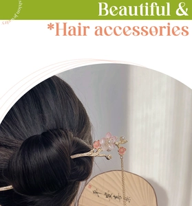 Close-up of golden plum blossom hair stick with pink flowers and long tassel pendant