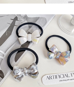 Detailed macro view of handmade marble-textured acetate bow scrunchies in various colors