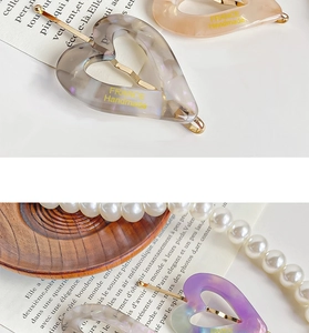 Detail of vintage heart hair clips with marble texture on French book pages