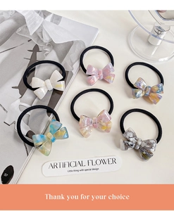 Flat lay of handmade acetate bow hair ties in various marble textures and colors