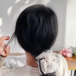 French style floral scrunchie with black rose print worn in a low ponytail