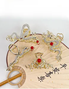 Detailed view of four golden dragon hair claws with rhinestones on a traditional paper fan
