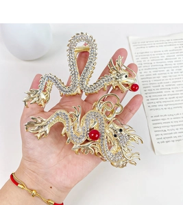 Detailed macro view of two dragon hair claws with gold finish and white rhinestones decoration