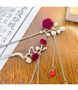 Detail of silver plum blossom hairpins with red velvet roses and elegant pearl tassels