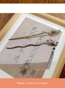 Detailed macro view of gold and silver dragon hair sticks with tassels and green beads