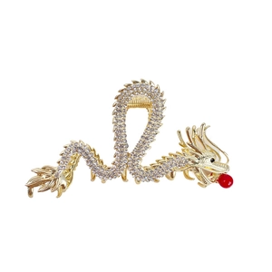 Golden dragon hair claw clip with white rhinestones and a red bead in a traditional style