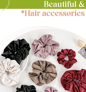 Flat lay of multiple satin scrunchies with glitter accents in a white tray with pearls